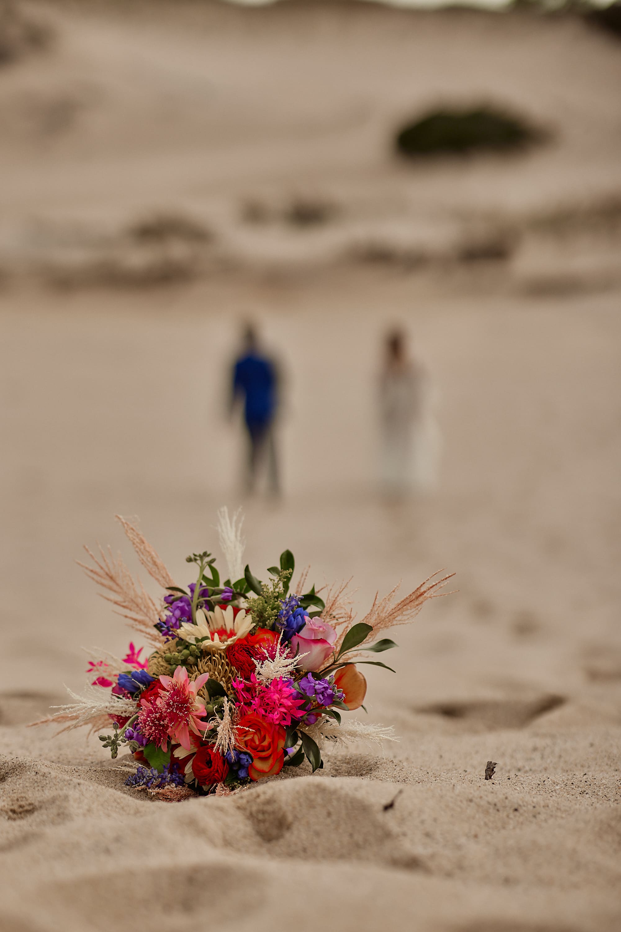Detailed shot of a colorful bridal bouquet on a sandy beach